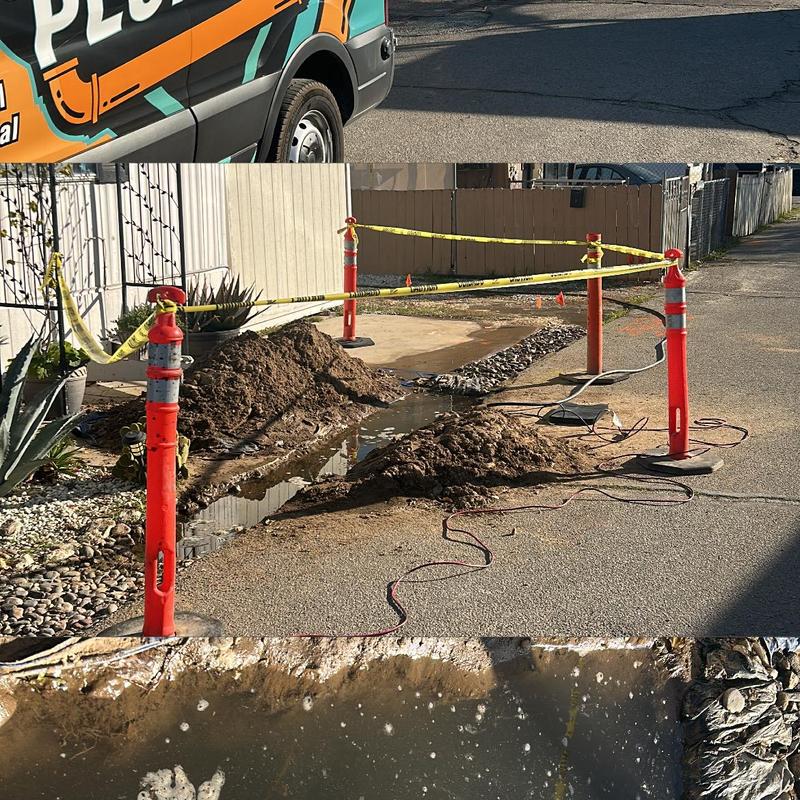 PVC water main pipe excavation and repair site with safety cones