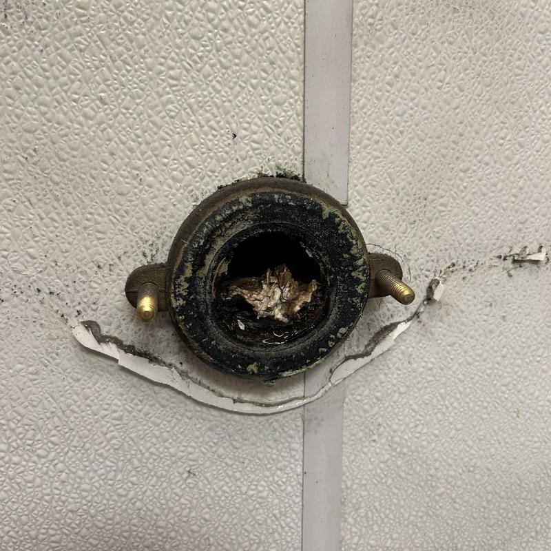 Urinal wall flange with blockage and corrosion