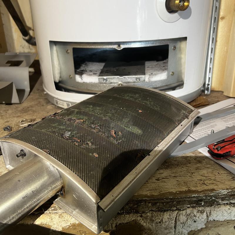 Water heater burner assembly removed for repair in workshop