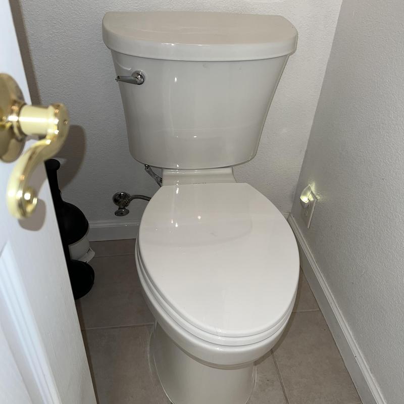 Elongated toilet installation in small bathroom corner