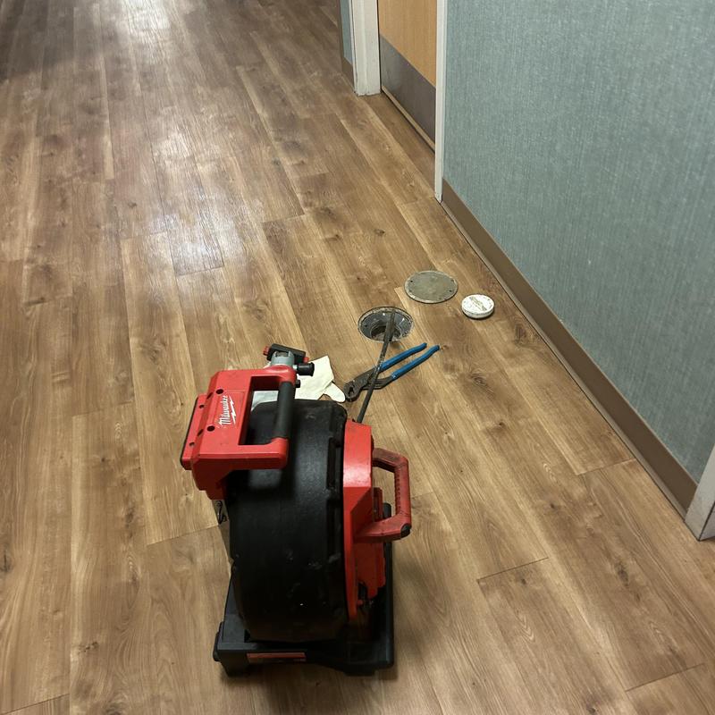 Main line drain with plumbing auger and tools