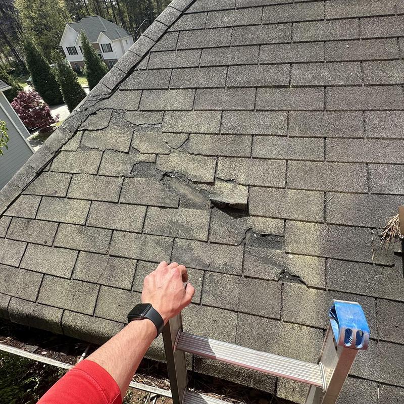 Roof shingles with cracking and lifting near ridge line