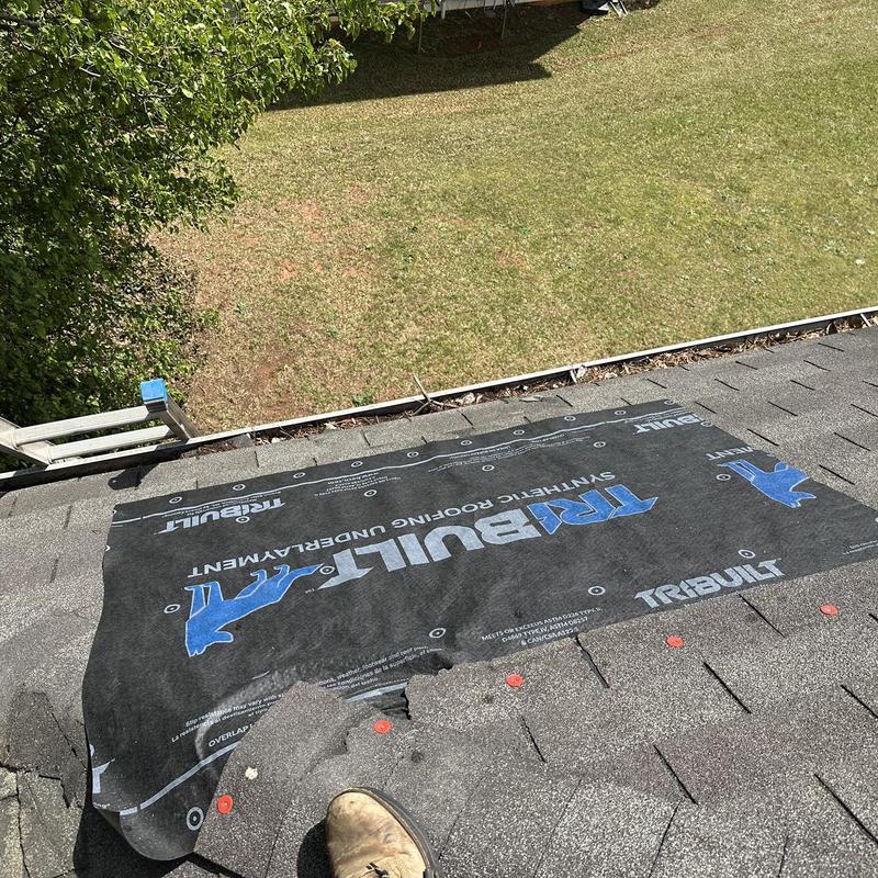 Roof decking underlayment tarp over damaged shingles and ridge caps