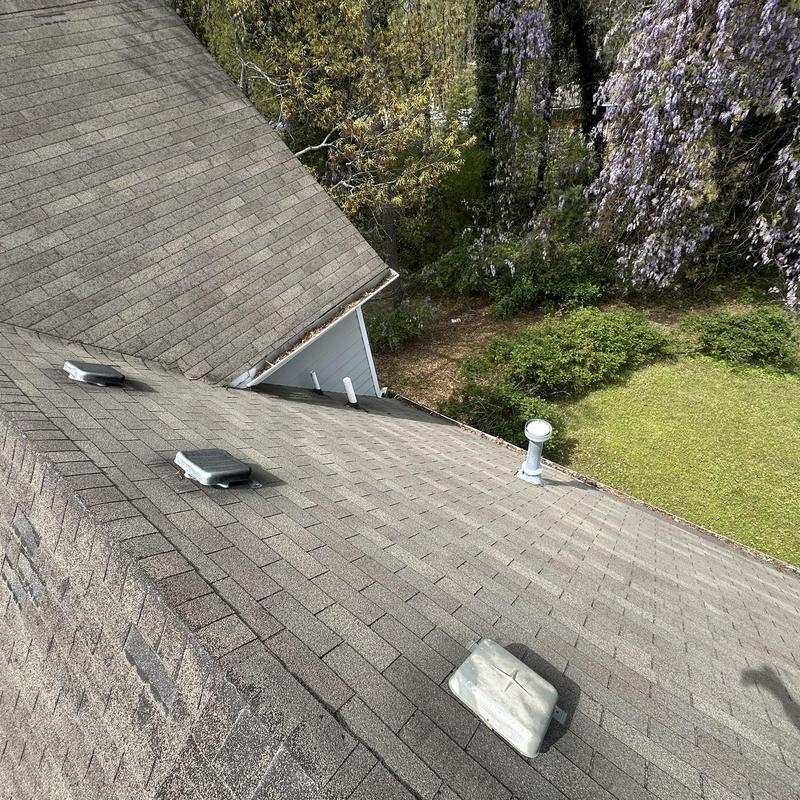 Asphalt roof shingles with wear and damage visible