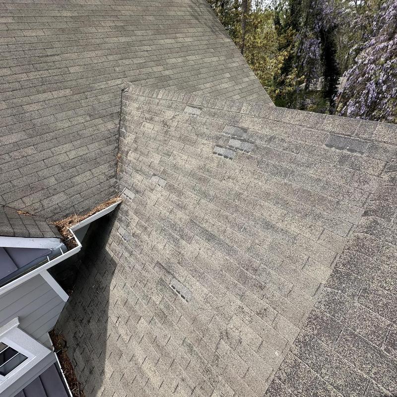 Asphalt shingles with damage and wear on roof surface