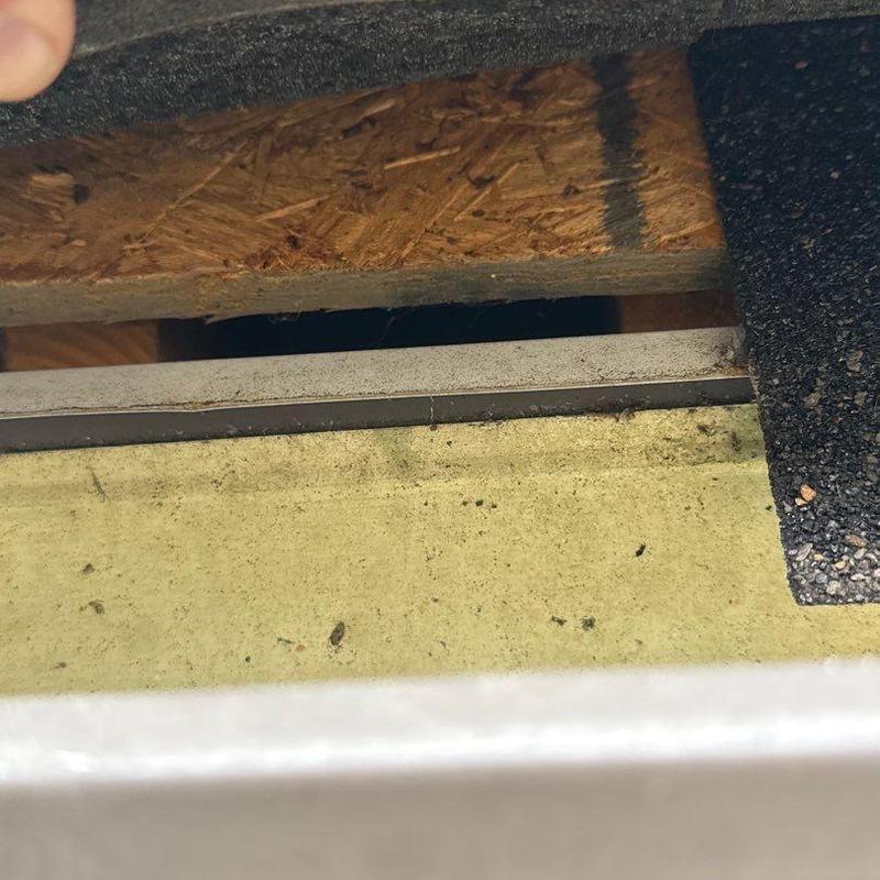 Asphalt shingle edge with underlying sheathing exposed