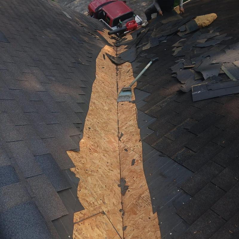 Roof valley with stripped shingles and exposed plywood sheathing