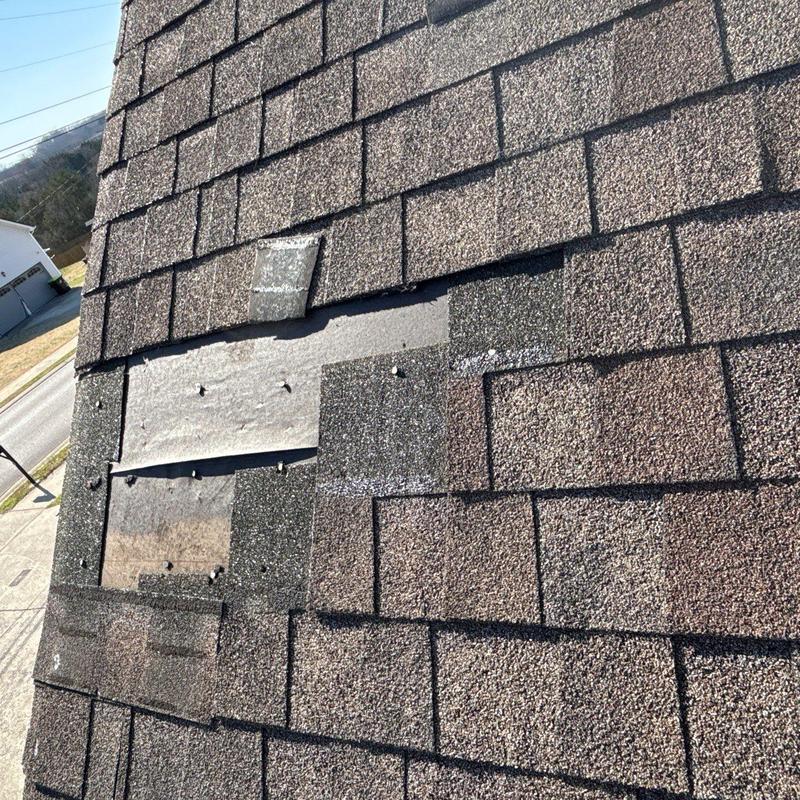 Asphalt shingles with missing sections and nail exposure on roof