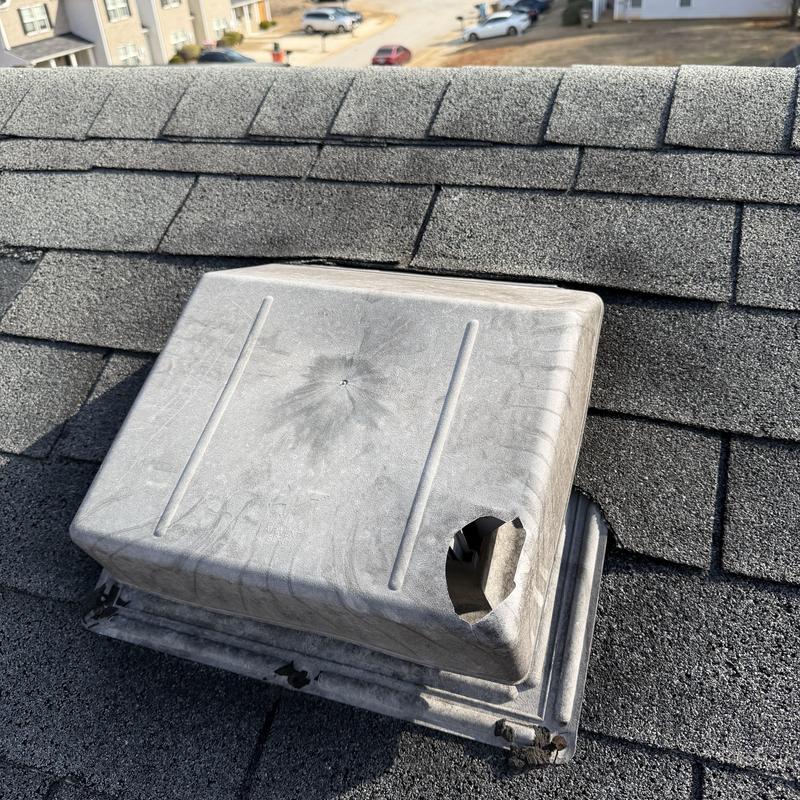 Box vent with hole on faded slate roof shingles