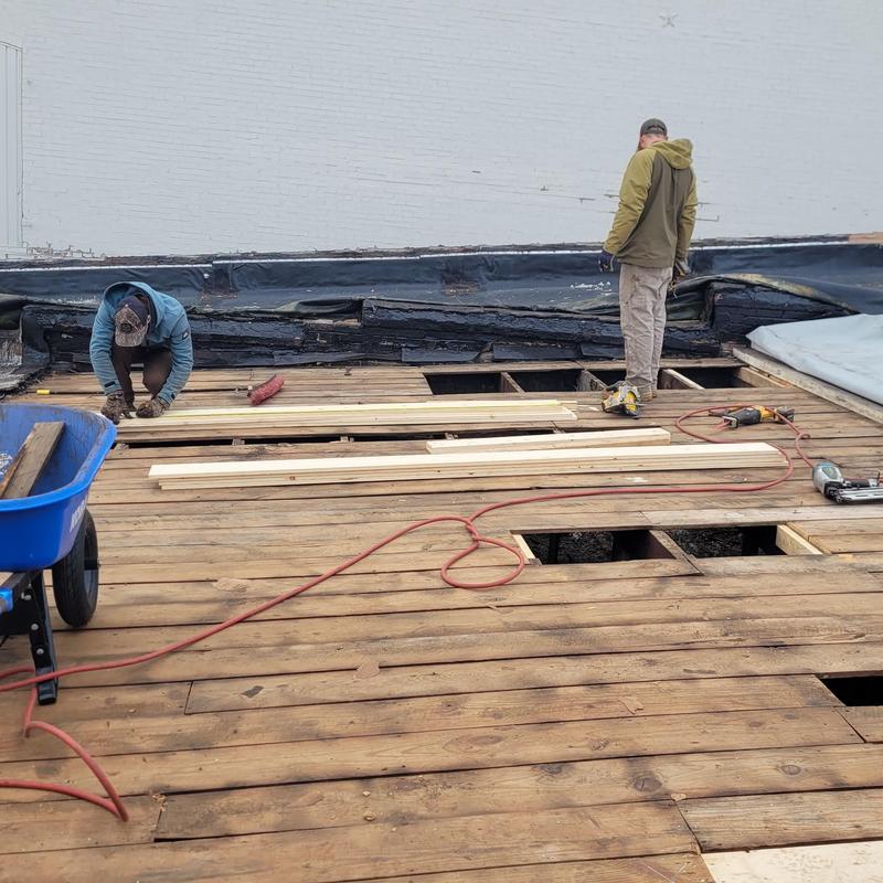 Commercial roof decking replacement with tools and workers