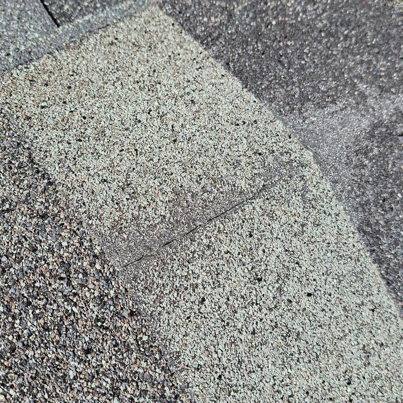 Shingle roof close-up showing granule wear and crack Shingle roof close-up showing granule wear and crack