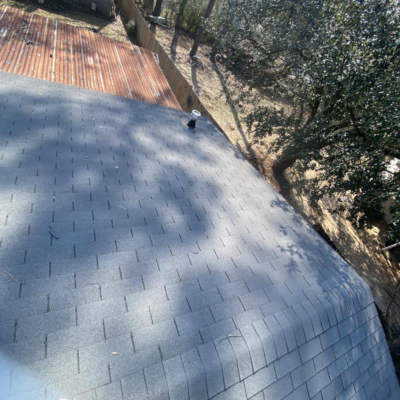 Asphalt shingle roof with vent pipe and rusted metal roof nearby Asphalt shingle roof with vent pipe and rusted metal roof nearby