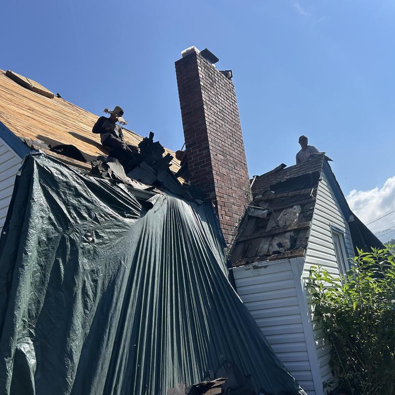 Black shadow shingles roof with chimney work in progress