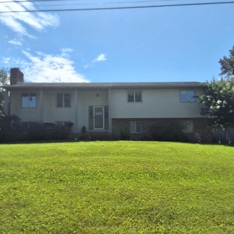 Residential roof with asphalt shingles under clear sky
