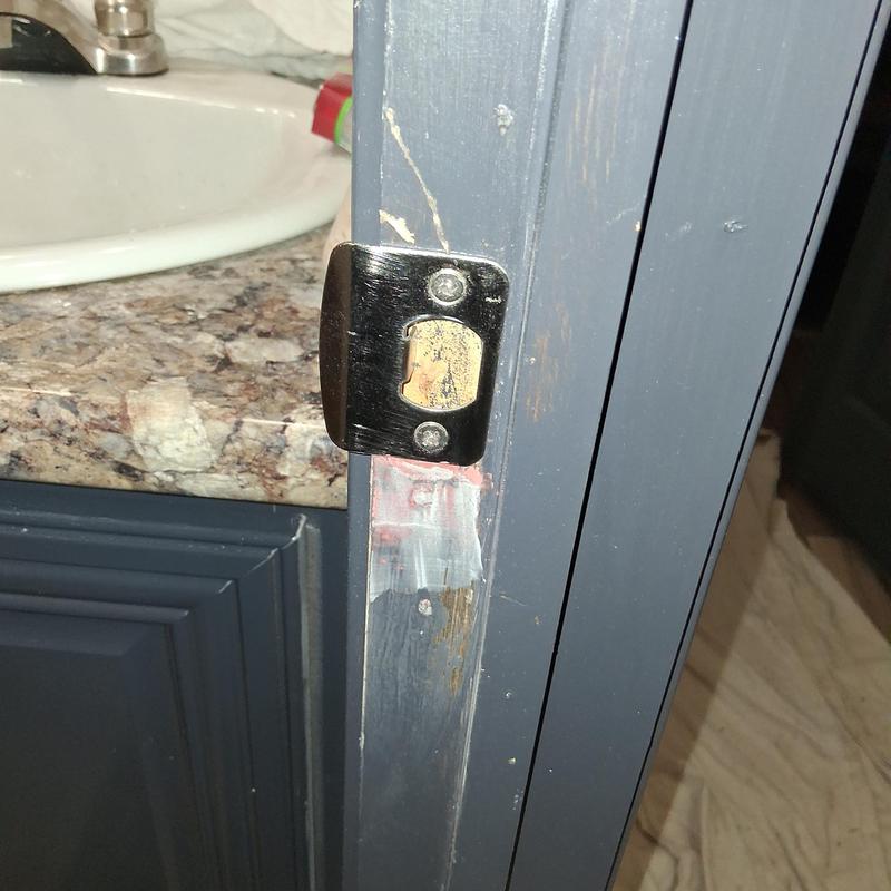 Latch plate on painted bathroom door frame during remodel Latch plate on painted bathroom door frame during remodel