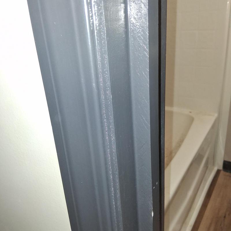 Door latch plate on gray door frame near tub Door latch plate on gray door frame near tub