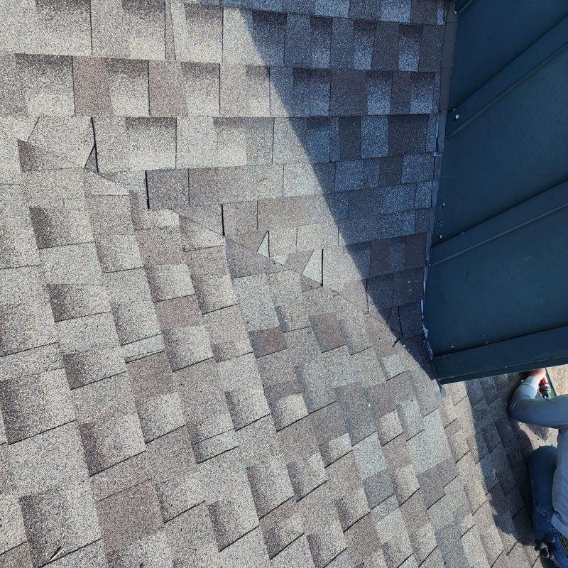 Step flashing and roof shingles at chimney base Step flashing and roof shingles at chimney base