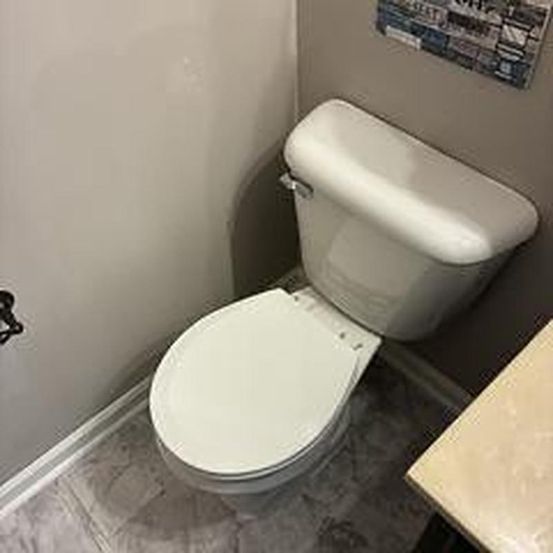 Round bowl toilet installation in bathroom corner