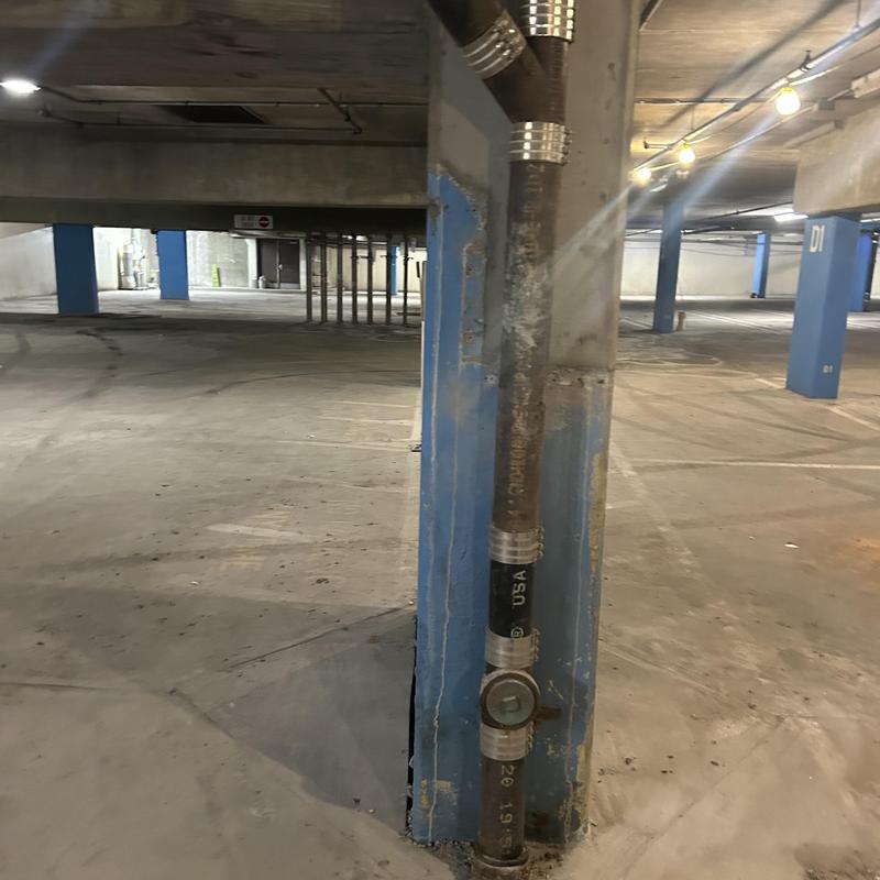 Sanitary sewer pipe with inspection access in parking garage