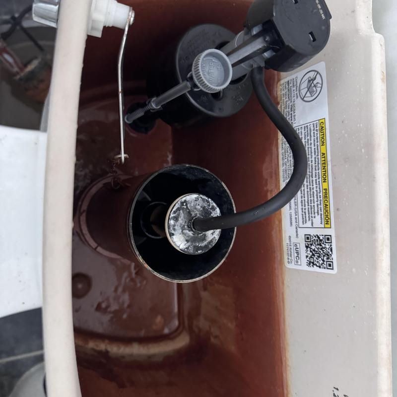 Toilet flush valve inside tank with corrosion buildup