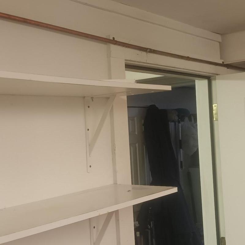 Copper repipe tubing above closet door frame in interior wall