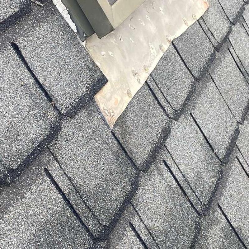 Roof shingles with hail impact near metal flashing