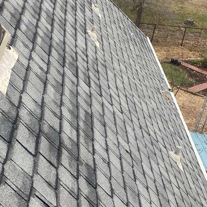 Asphalt shingle roof with hail damage and patched spots