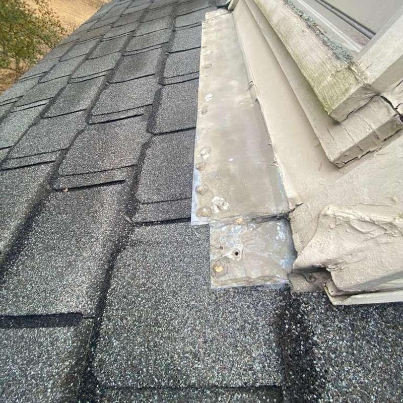 Asphalt shingle roof with hail damage near metal flashing