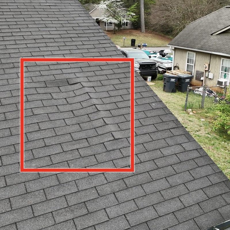 Roof shingles with visible buckling and damage