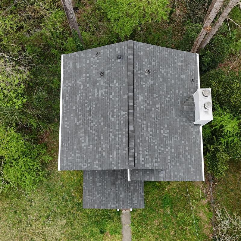 Roof shingles with one damaged shingle visible
