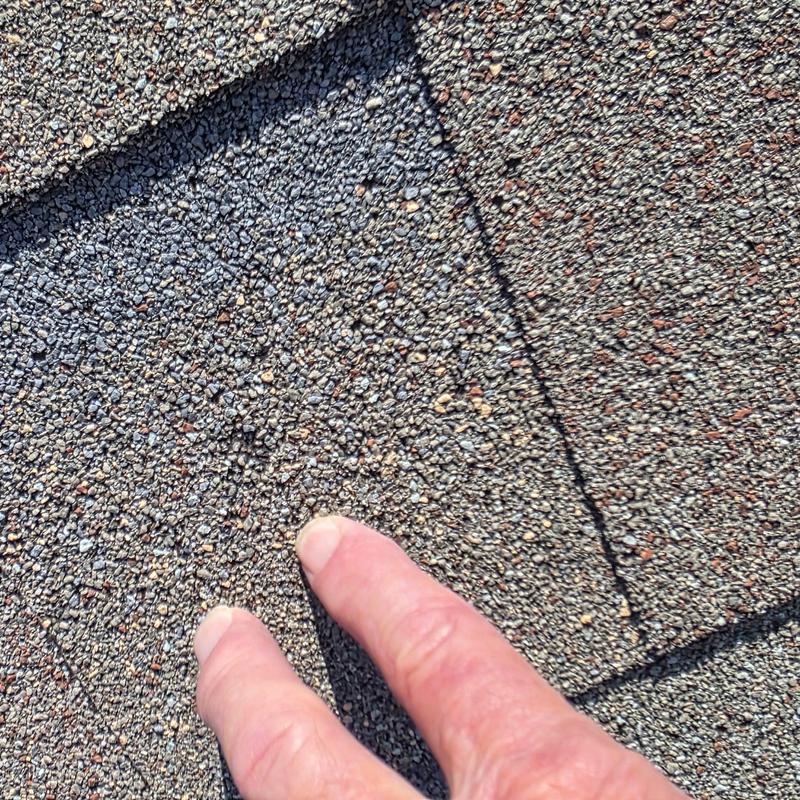 Asphalt shingle roof with hail and wind damage close-up