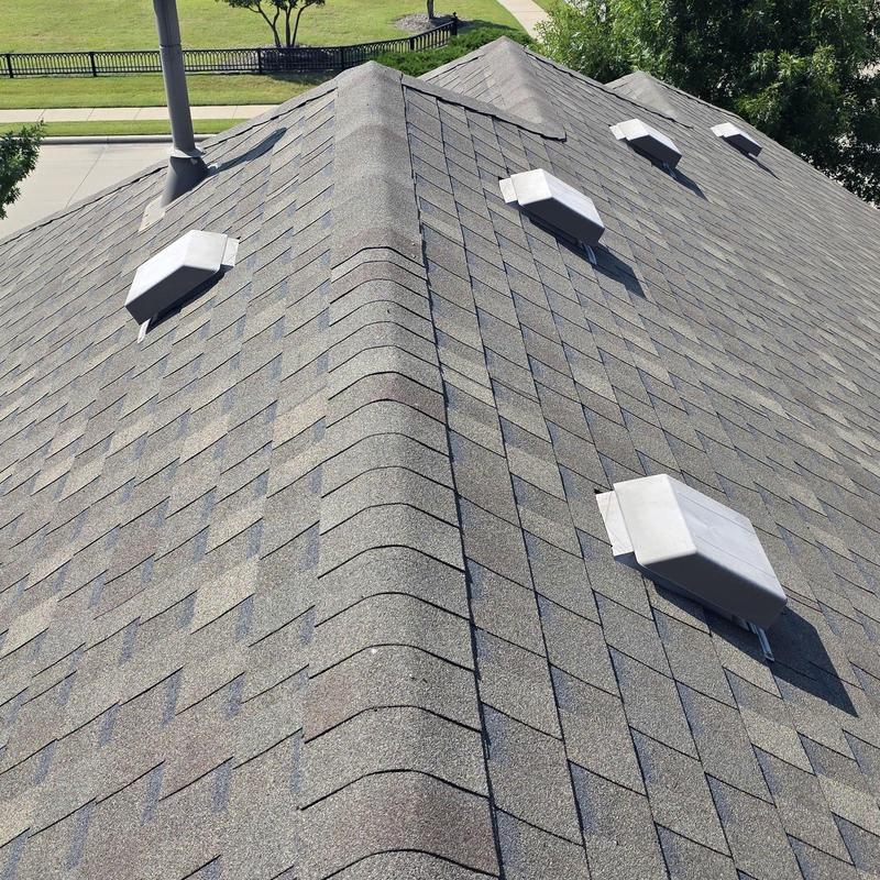 Asphalt shingle roof with vent covers after hail damage