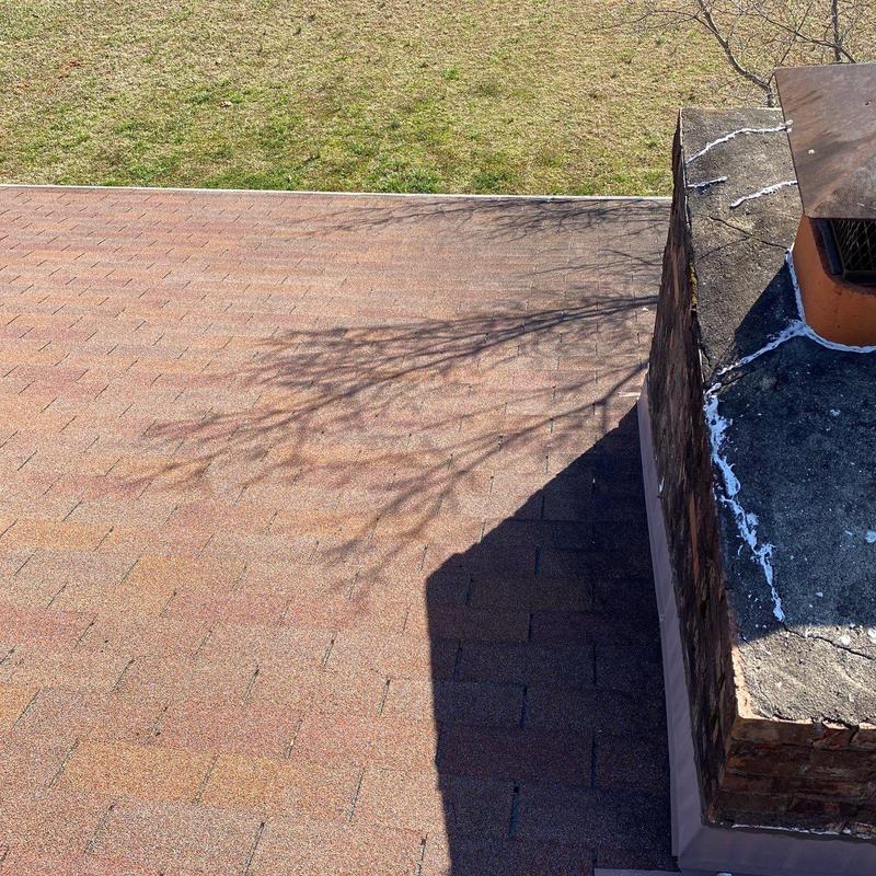 Roof shingles with chimney flashing and sealant repairs