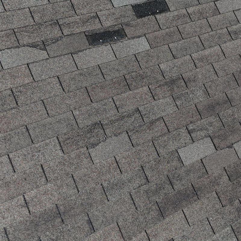 Asphalt shingle roof with hail damage and wear spots