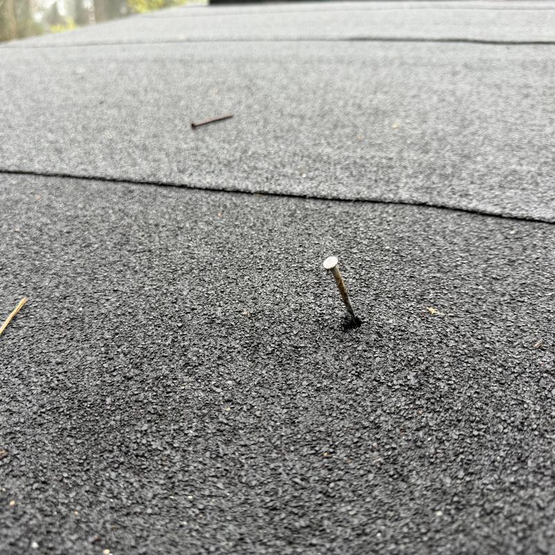 Rolled roofing nail pop on black 2-story roof