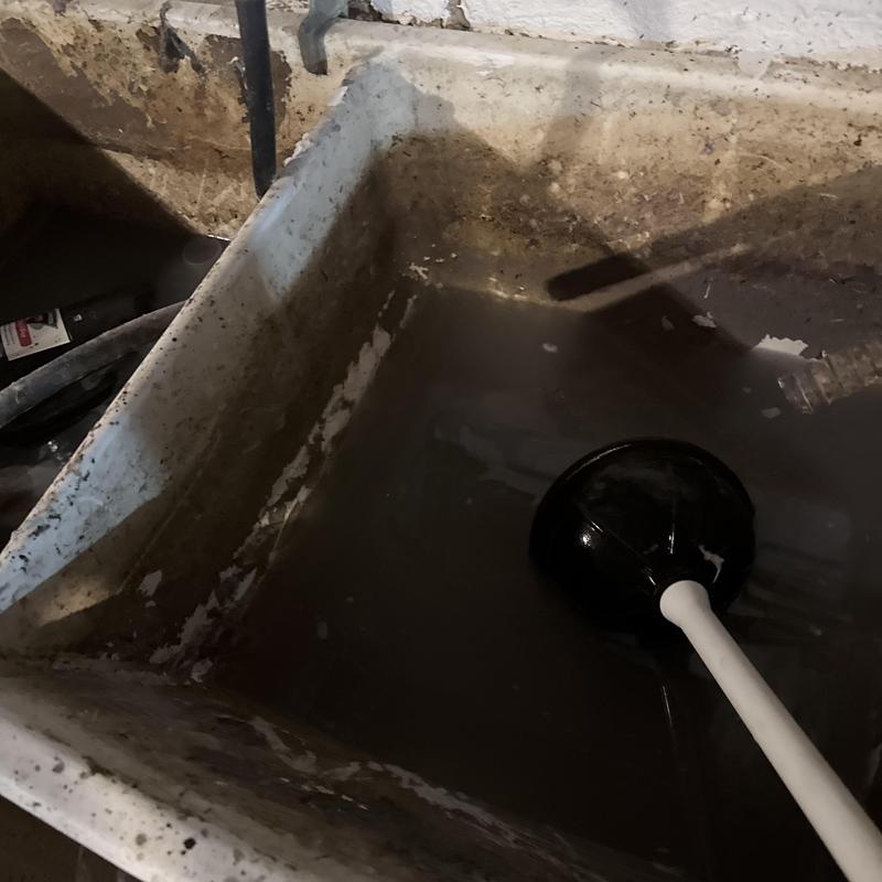 Laundry tub drain with plunger in basement