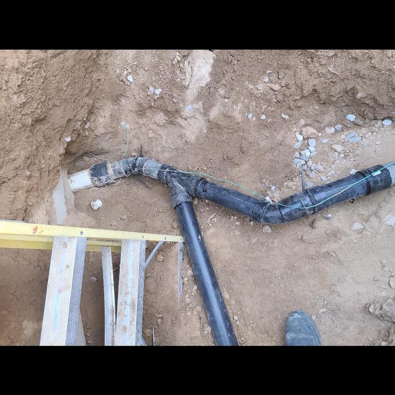 Sewer line connection to septic tank in trench