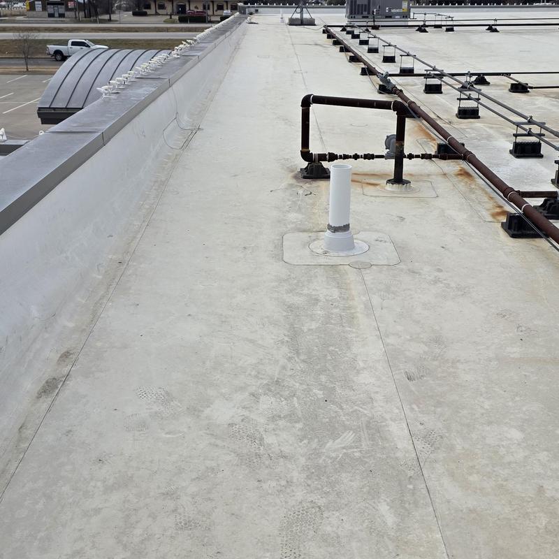 Flat commercial roof with pipe vent and rusted pipes