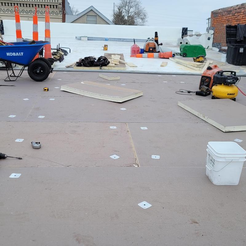 Insulation board installation on roof deck with tools