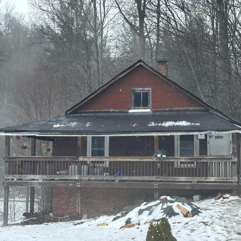 Roof shingles with wear and snow on old house