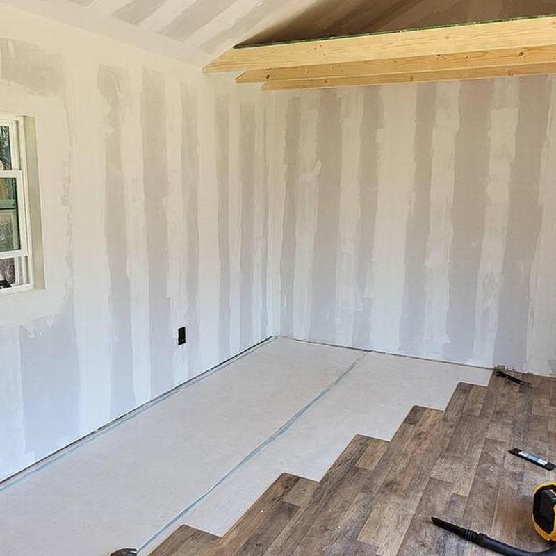 Sheetrock installation with wall insulation in work shed