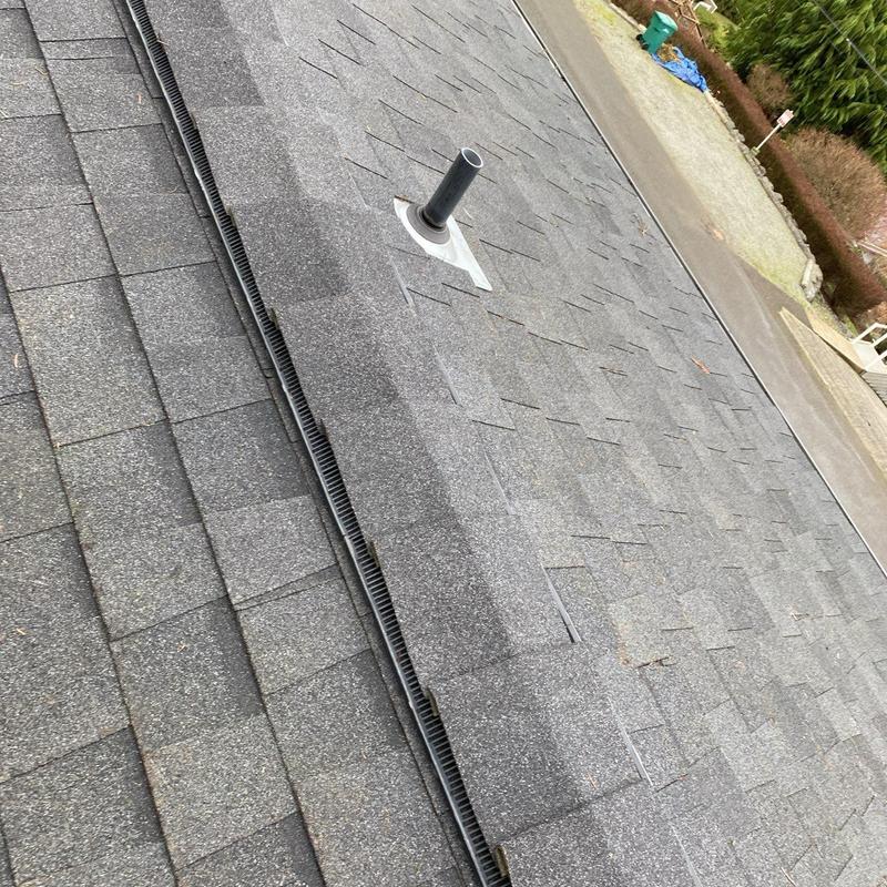 Asphalt shingle roof with vent pipe and ridge vent installation