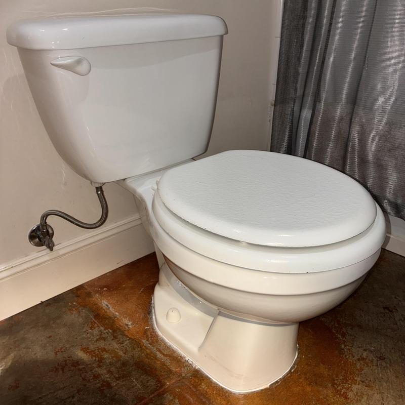 Toilet with shim and recaulked base seal