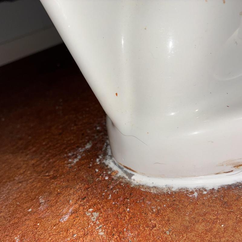 Toilet base recaulked with shim for leveling