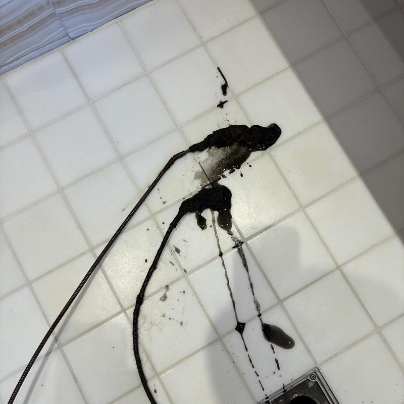 Shower drain clog removal with plumbing snake tool