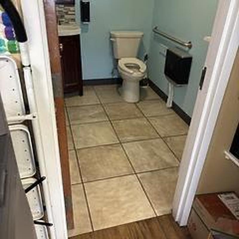 Toilet and floor tile in commercial bathroom interior