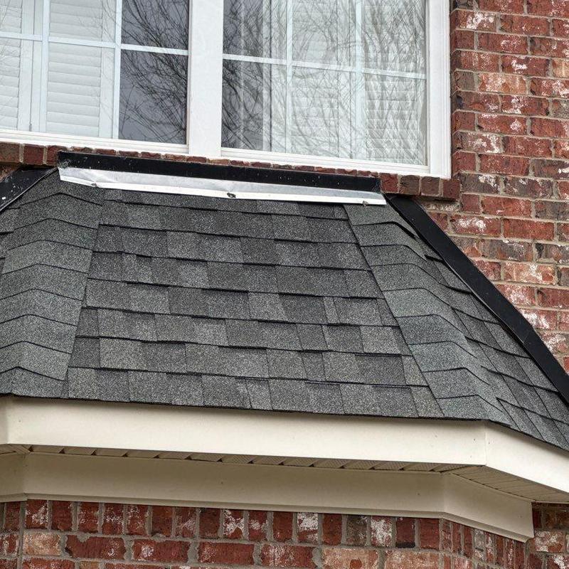 Roof shingles with hail damage near window flashing
