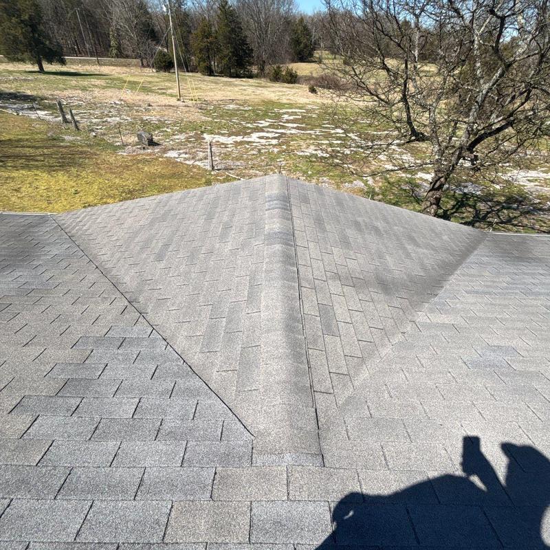 Asphalt shingle roof ridge with hail damage inspection