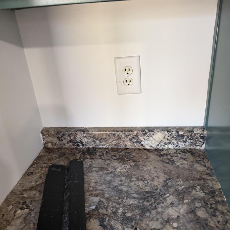 Electrical outlet cover on kitchen countertop wall Electrical outlet cover on kitchen countertop wall