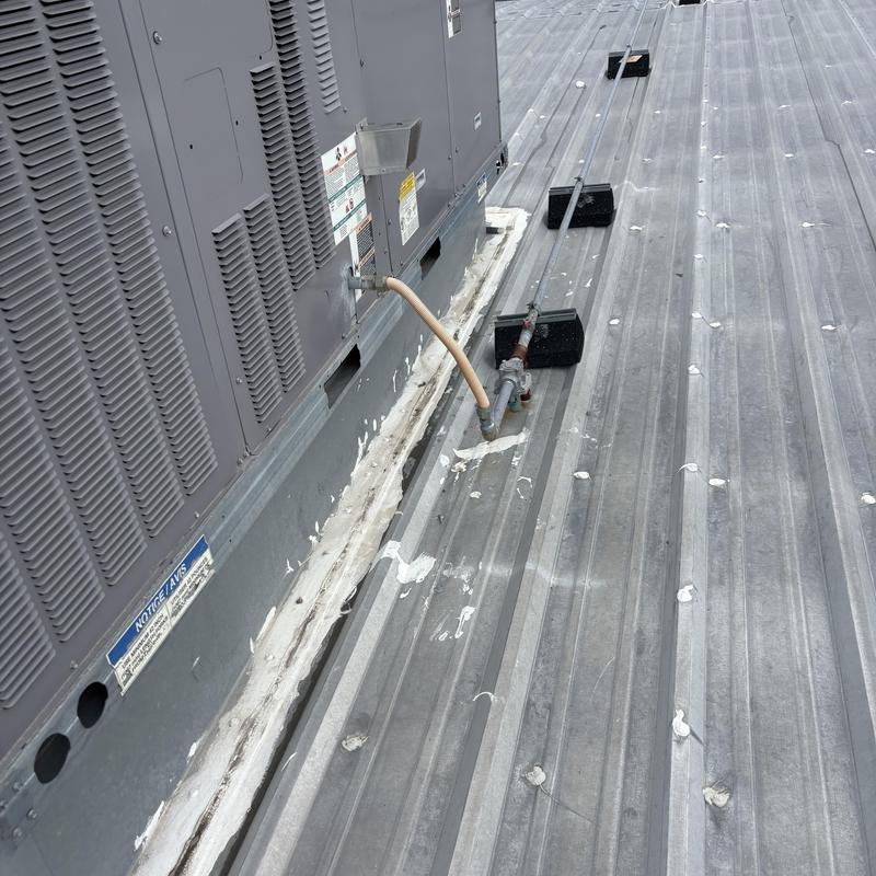 Commercial metal roof with HVAC unit and piping